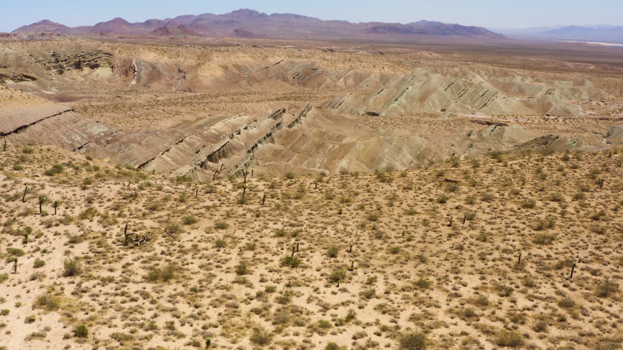 volando hacia uno de los profundos valles geológicos que forman la cuenca del arco iris en el desierto de mojave y mirando hacia abajo