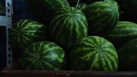 panning shot of fresh watermelons for sale in a small supermarket