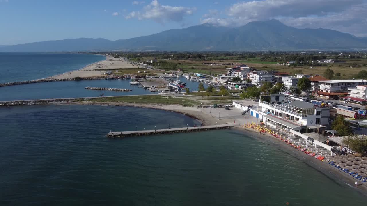 vista aérea de la playa y el puerto pesquero de paralia, grecia. el monte olimpo en el fondo.