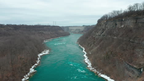 aerial shot of high hills on either side of green blue river