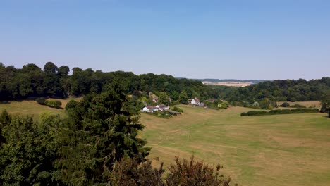 revelan el aumento de la toma aérea de drones del antiguo pueblo de la campiña inglesa y los campos y árboles verdes quemados dorset uk 4k