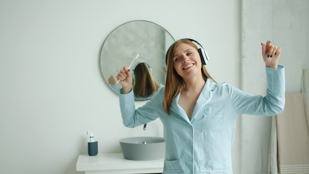 Happy Woman Dancing in Pajamas while Brushing Teeth