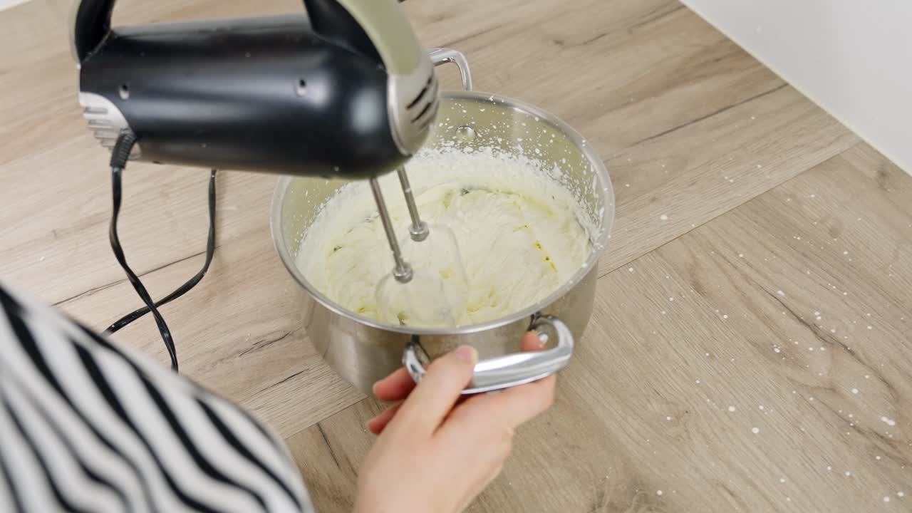Clip of cream being mixed in a bowl as part of tiramisu dessert making