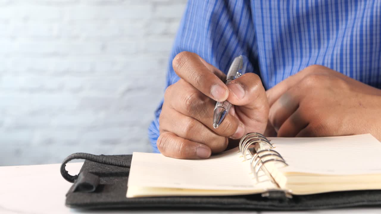 Person Writing in a Notebook