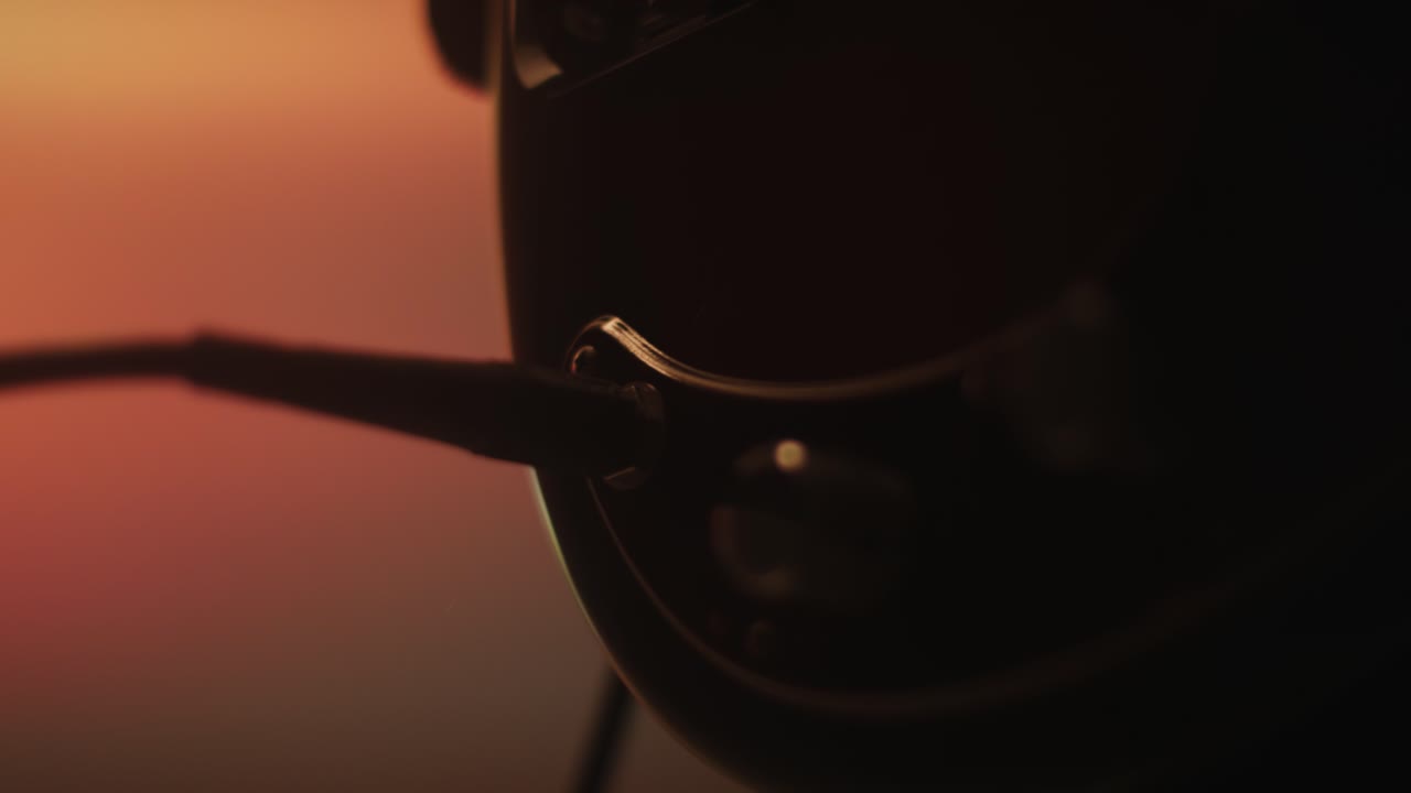 Silhouetted hand unplugging and plugging a cable from an electric bass guitar