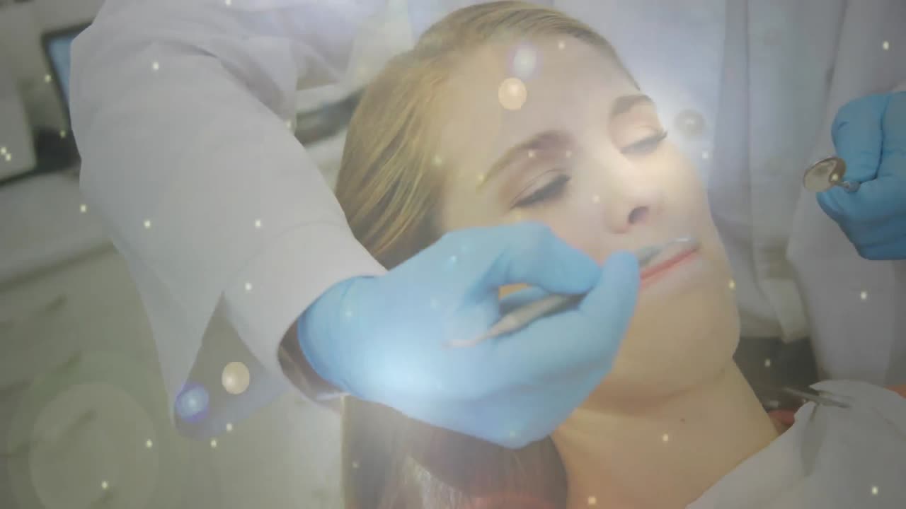 manchas brillantes de luz que se mueven contra el dentista que trata a la paciente