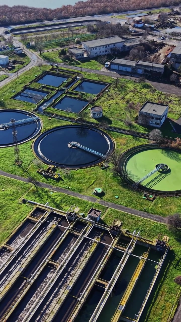 Water treatment facility with tanks and surrounding area in daytime