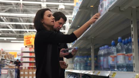 couple shopping for water bottles in a grocery store
