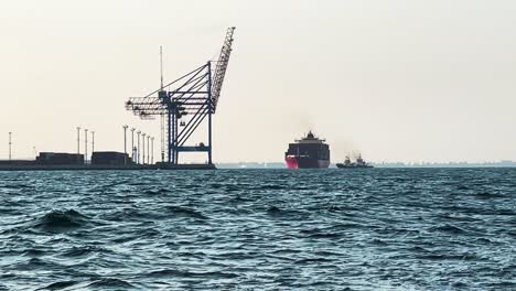 cargo ship with tugboat docked at harbour in odesa, ukraine from a boat