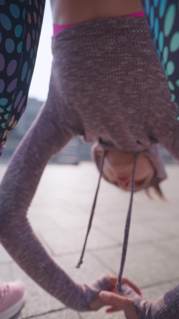 Woman doing an inversion yoga pose outdoors