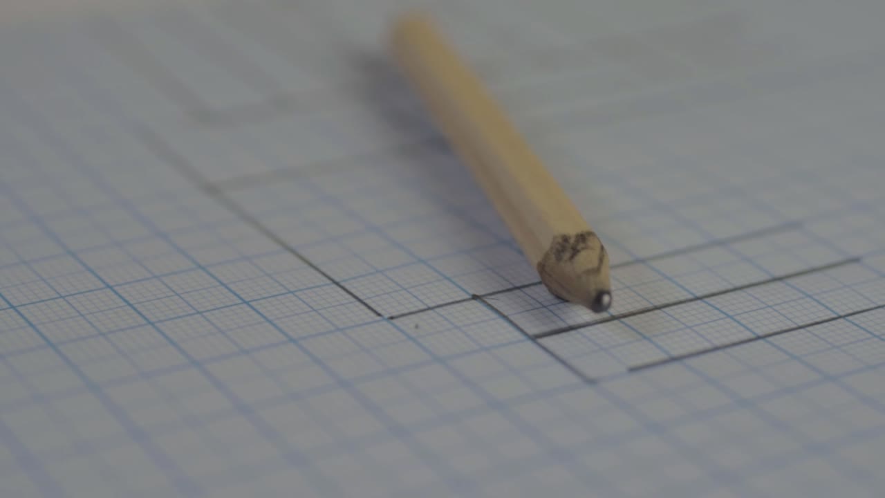 Pencil and drawings on graph paper close up panning