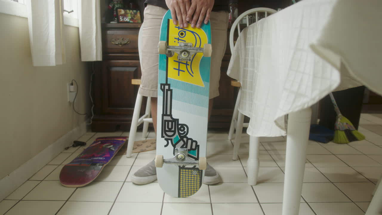 Person holding a skateboard indoors