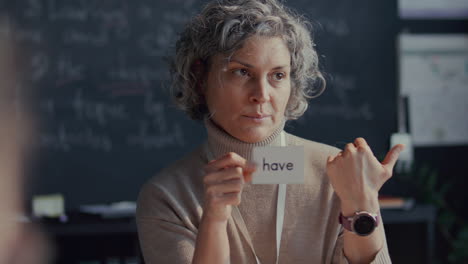 english teacher using flashcard to explaining verb to students during lesson