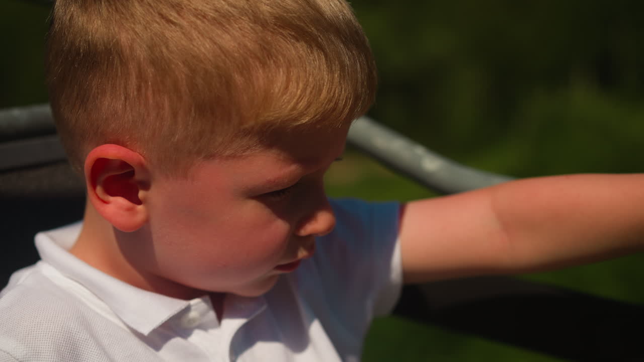 폴로를 입은 사려 깊은 소년은 케이블카를 타고 시간을 보내고, 어린 아이는 산과 숲의 멋진 전망을 즐기며 휴식을 취합니다.