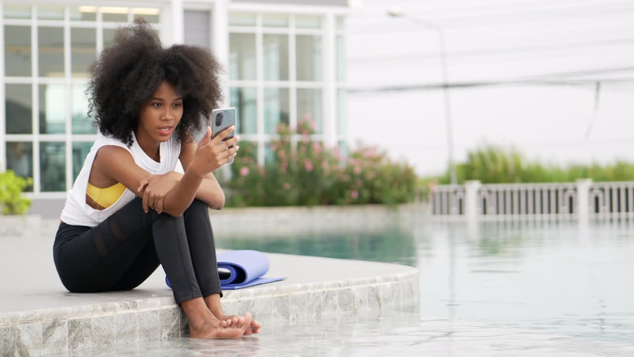 A female dressed for exercise talking smart phone video call.