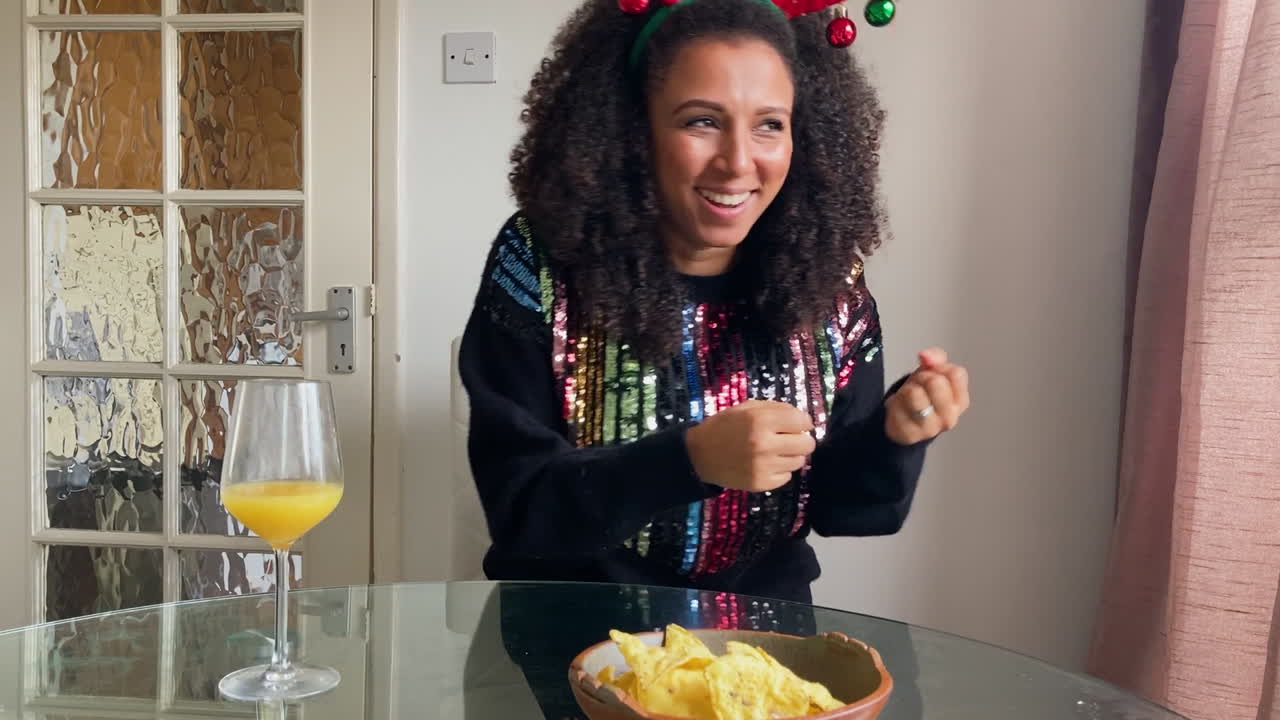 mujer joven en videollamada navideña actuando palabra durante un juego de charadas