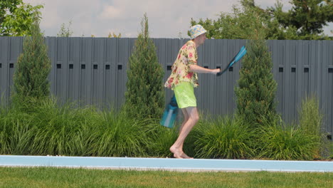 man with flippers by the pool