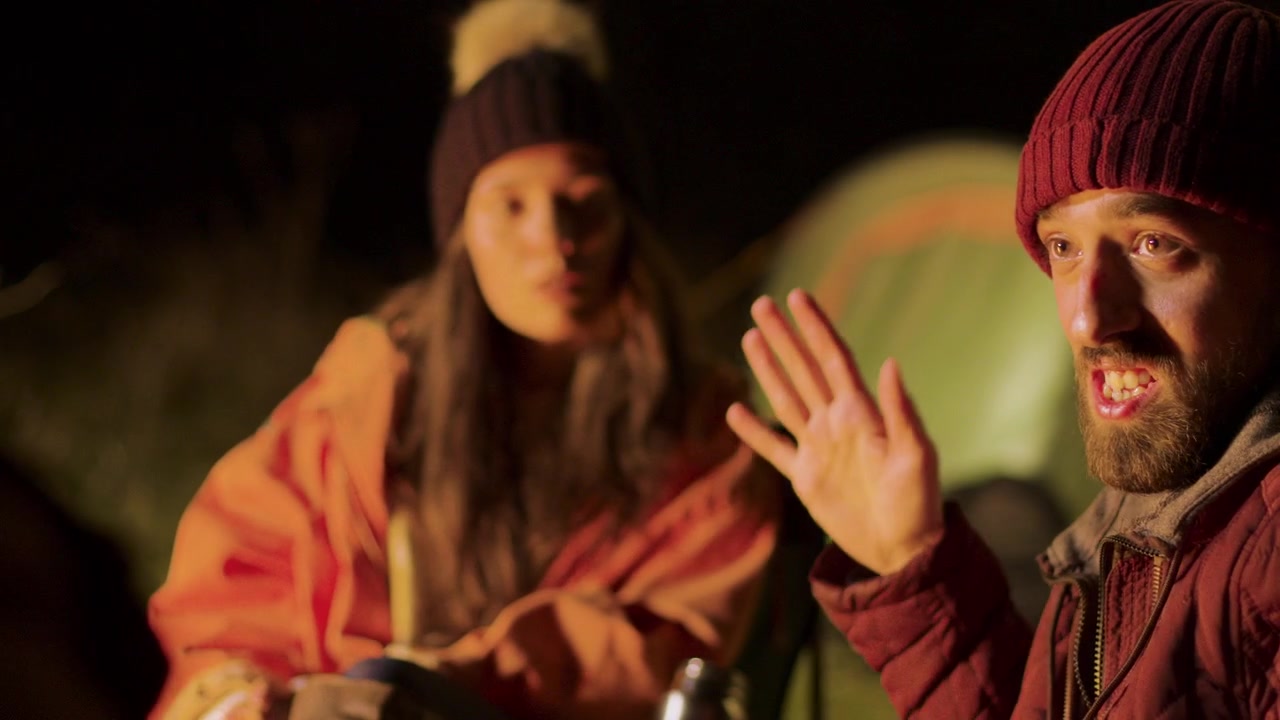Bearded man shares a campsite story with friends