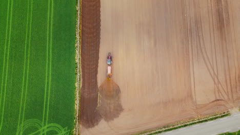 top-down shot of a farmer spraying his field with fertiliser to aid crop growth