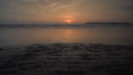 Young-woman-with-untied-bouncing-let-down-hair-running-at-the-beach-with-dumbbells-in-her-hands-at-dusk