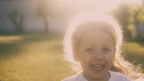 little girl runs and back sunlight creates halo around hair