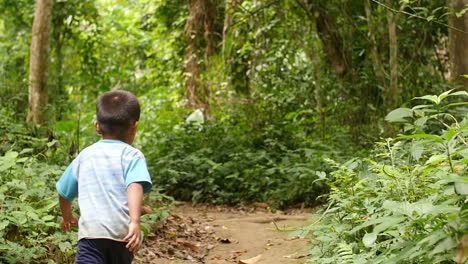 boy walking through a lush forest