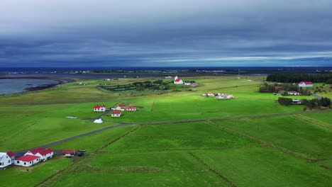 distant view of gardakirkjugardur cemetery and gardakirkja church in gardabaer, southwest iceland