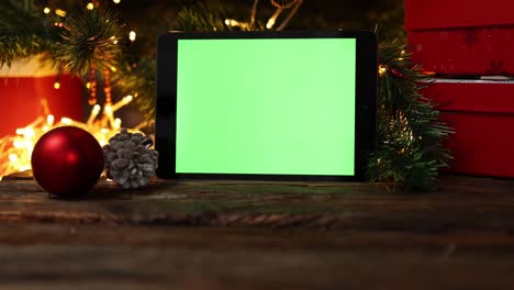fondo de navidad caja de regalo roja tablet gadget pantalla verde luces de mesa de madera