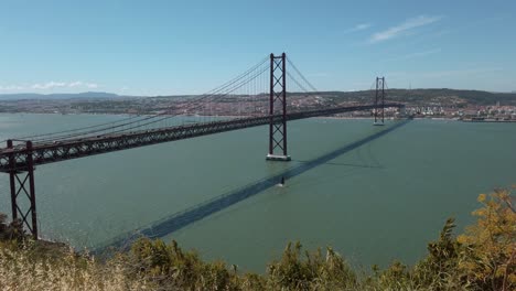 ponte 25 de abril bridge spans tagus river to connect almada with lisbon on far bank, portugal