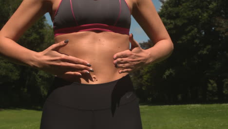 tone woman touching abdominal muscle