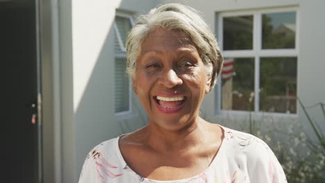 Video-of-african-american-senior-woman-standing-outside-house