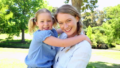 Glückliche-Mutter-Hält-Ihr-Kleines-Mädchen-Im-Park