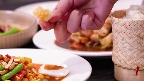 close-up of sticky rice being served alongside vibrant vegetable dishes in woven containers.