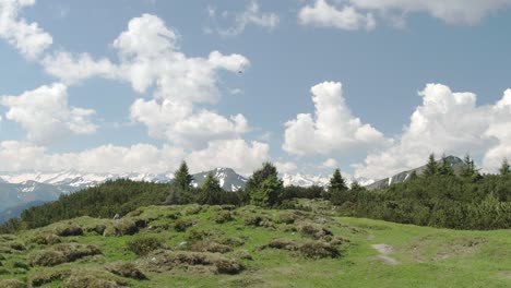 Toma-De-Camión-De-Paisaje-Idílico-Con-Montañas-Nevadas-Y-Parapente-Volador-En-El-Cielo-En-Verano---Dolomitas,-Italia