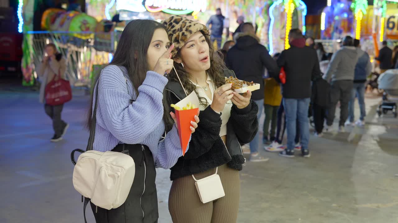 Two Friends Enjoying Fries at a Night Fair