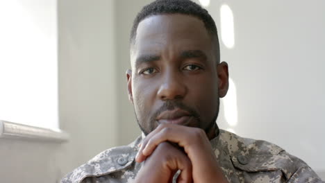 african american soldier in military uniform appears contemplative at home