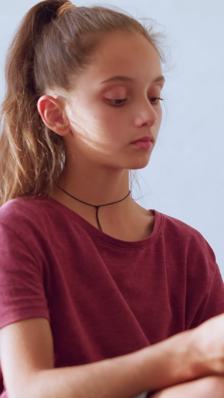 Caring sister gently removes thermometer from younger brother mouth to check temperature while sitting on bed in cozy room showing love compassion