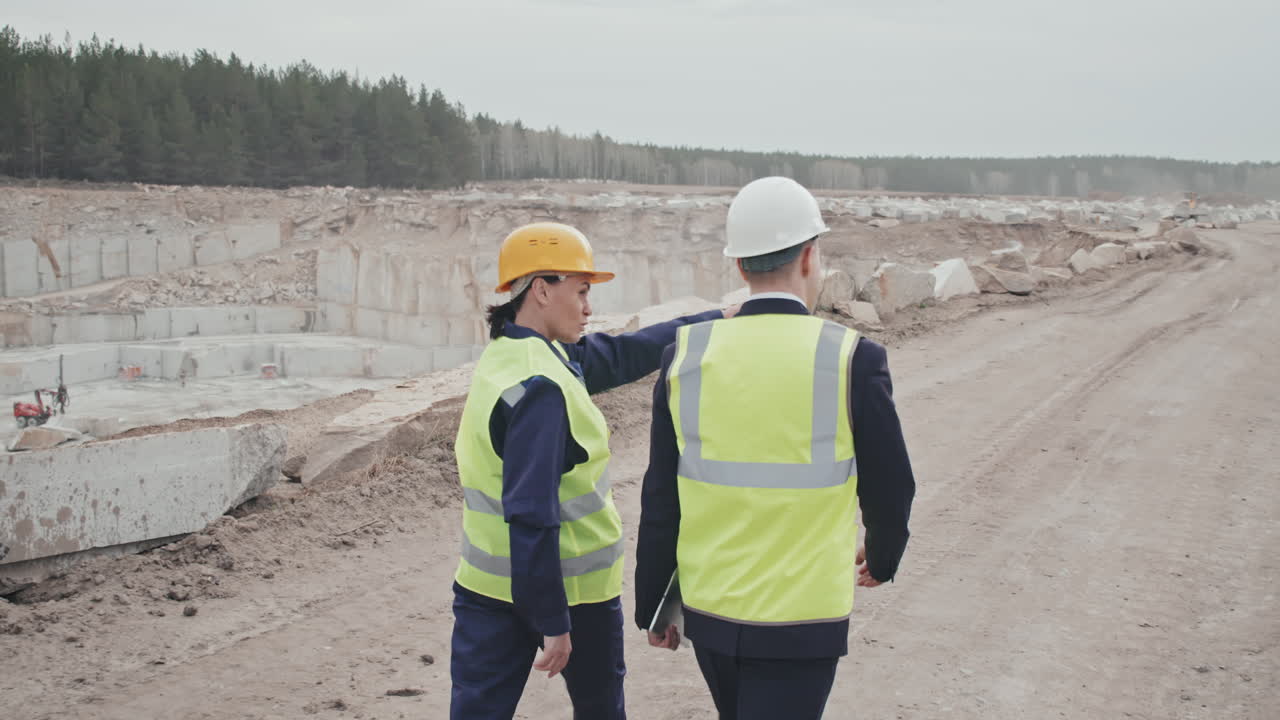 Female Quarry Supervisor and Male Manager Walking
