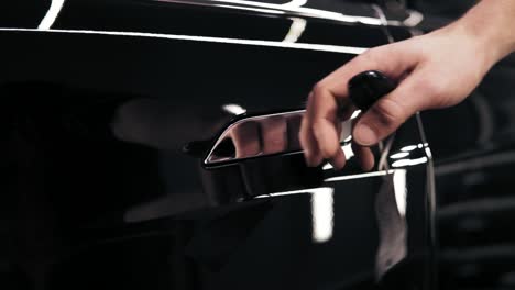 Slomotion-footage-of-unrecognizable-male-hand-unblocking-car's-chrome-tanned-handle.