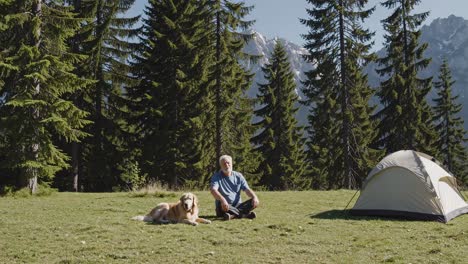 man and dog camping in mountains