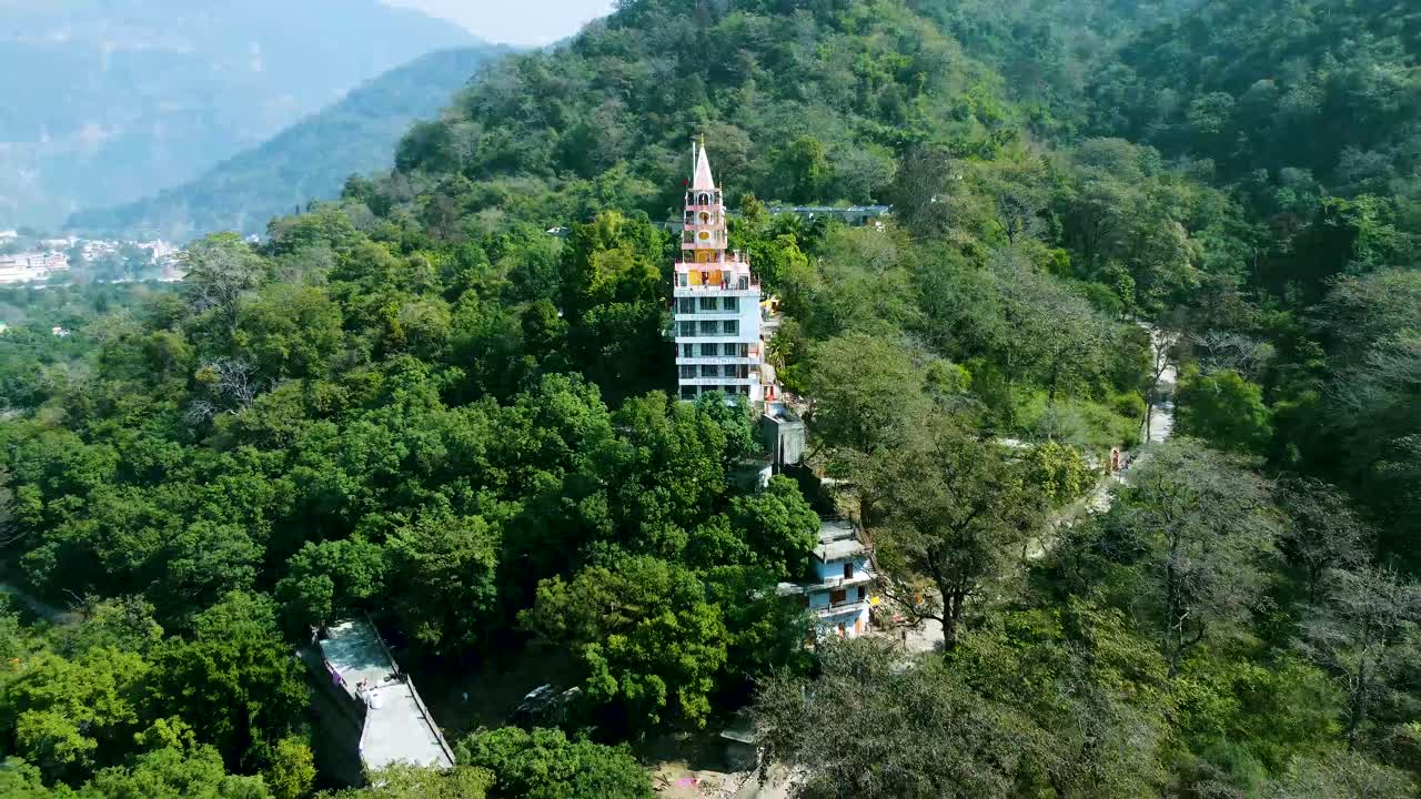aislamiento de un templo hindú de varios pisos en el medio de los bosques desde diferentes ángulos. se toma un video aéreo en el templo de bhutnath, rishikesh, uttarakhand, india, el 15 de marzo de 2022