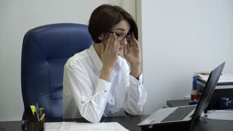 mujer con dolor de cabeza y estrés en la oficina