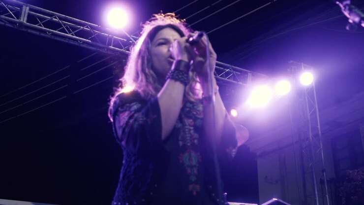 Cantante donna che si esibisce sul palco a un concerto all'aperto