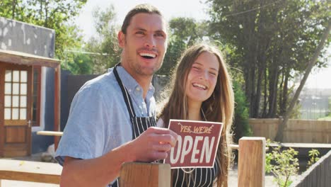 video de felices vendedoras y vendedores caucásicos en una cafetería con un cartel abierto