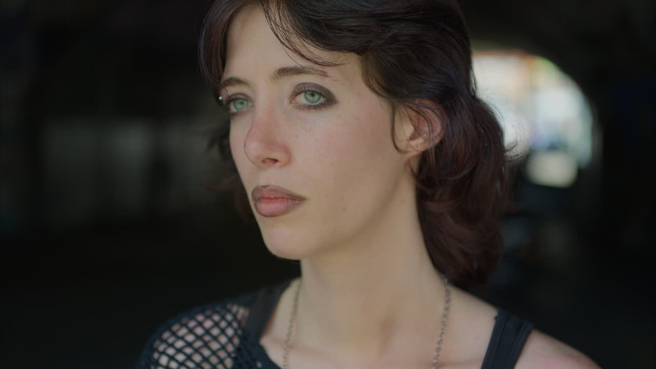 ansiosa joven estilo alternativo mujer caminando a lo largo de un paso subterráneo oscuro con paredes cubiertas de graffiti en la calle de la ciudad de londres reino unido en tiempo real 4