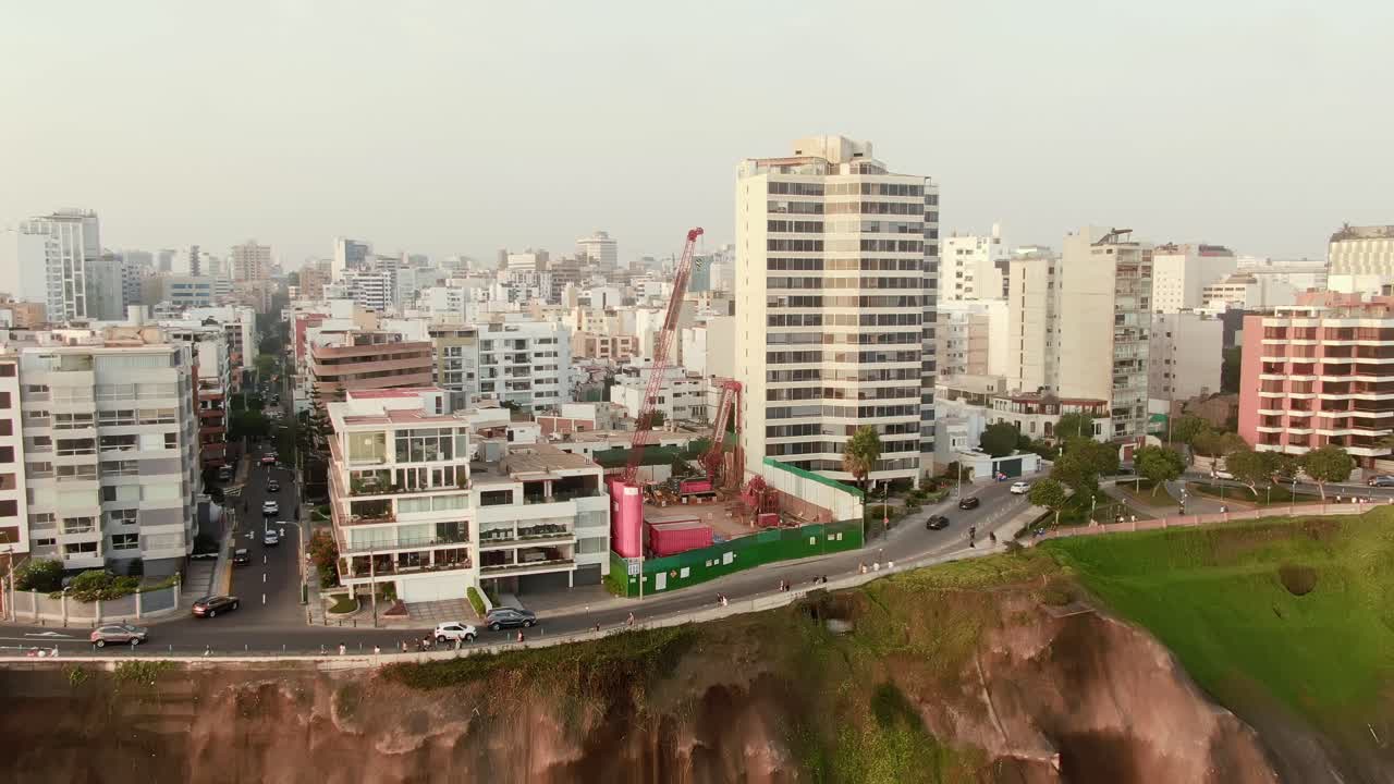 City buildings on cliffs above Malecon de la Reserva, Miraflores, Lima at sunset