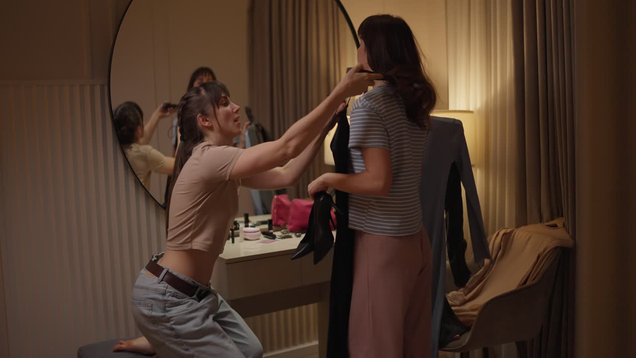 Two friends getting ready in a bedroom