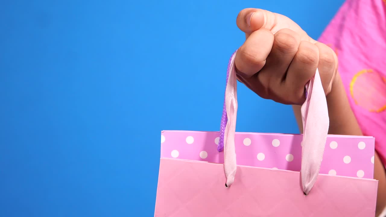 bolsa de compras rosada con puntos de polca en la mano