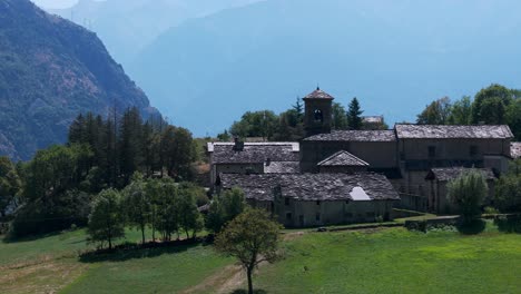 Aerial-View-of-Novalesa-Abbey,-a-Benedictine-monastery-nestled-in-the-lush-landscape-of-Piedmont,-Turin,-Italy