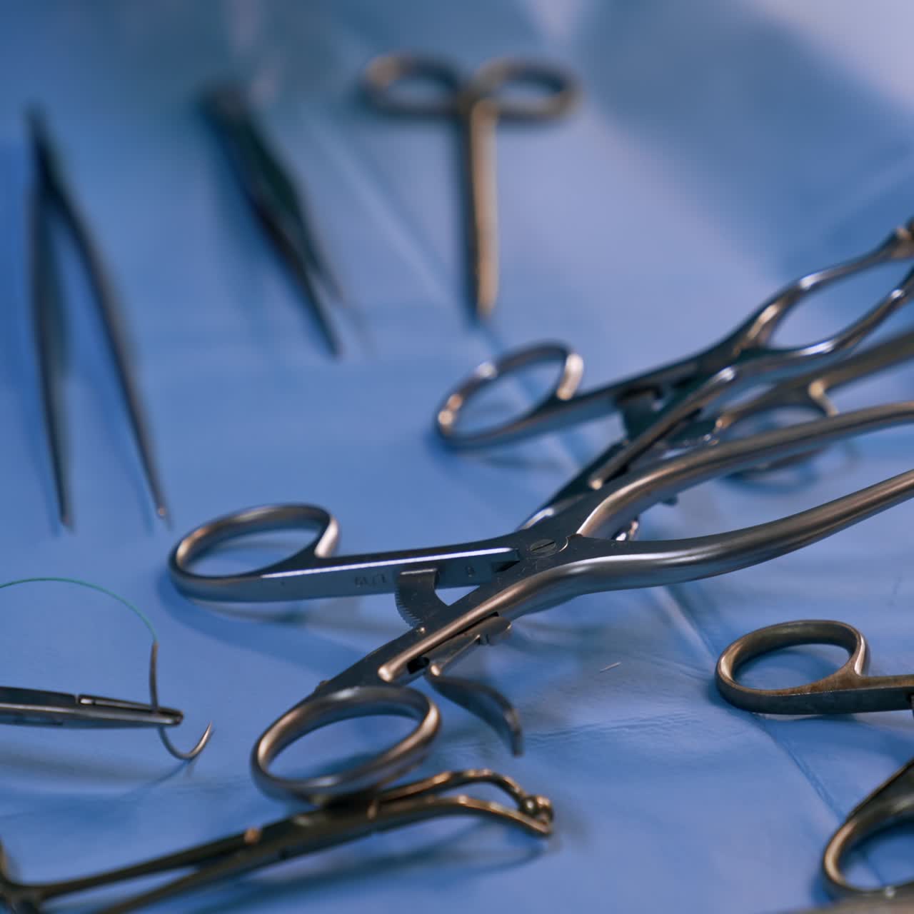 Metal tools for the surgical operation. Instruments on the blue backdrop. Close up